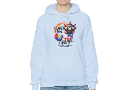 Model wearing a light blue hoodie with a colorful unicorn pug and the text "I Came, I Saw, I Made It Awkward," standing with hands at sides. Part of the Vivid Divergence Sensory Friendly Unisex Hoodie Range.