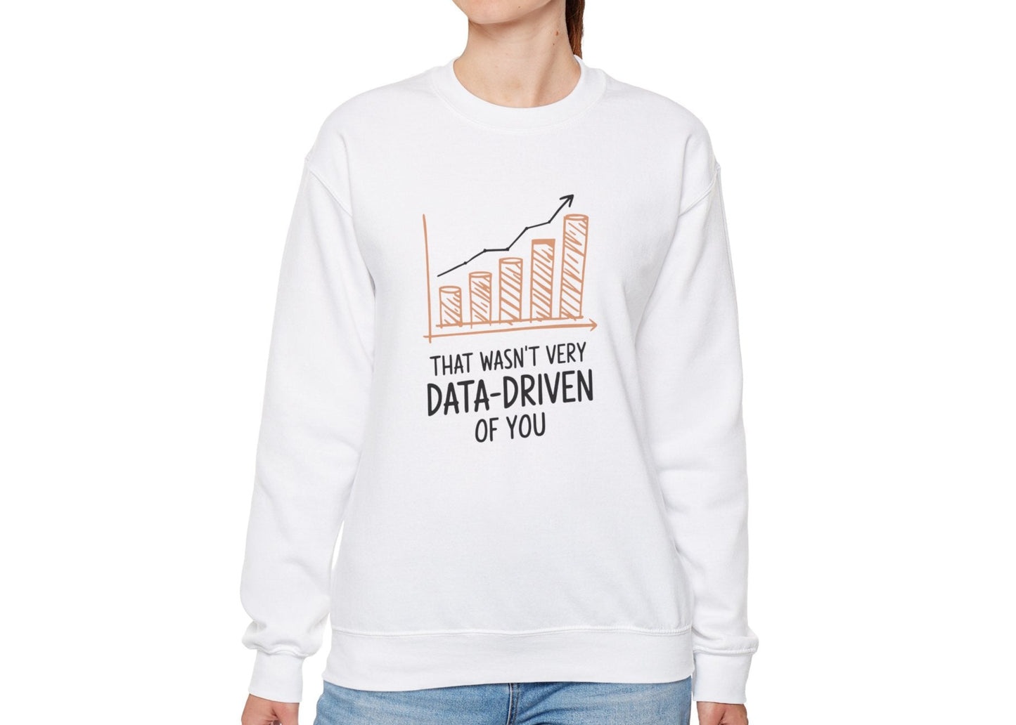 Model wearing a white sweatshirt with a rising bar graph illustration and the text "That Wasn't Very Data-Driven of You," standing with hands at sides. Part of the Vivid Divergence Sensory Friendly Unisex Sweater Jumper Range.