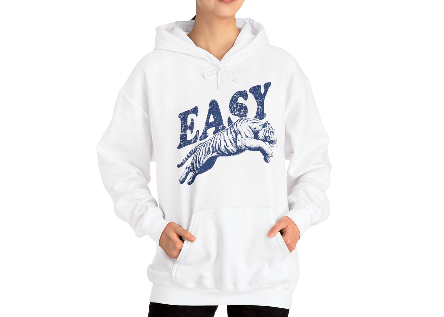 Model wearing a white hoodie with "EASY" in blue letters and a leaping tiger graphic, standing with hands in pockets. Part of the Vivid Divergence Sensory Friendly Unisex Hoodie Range.