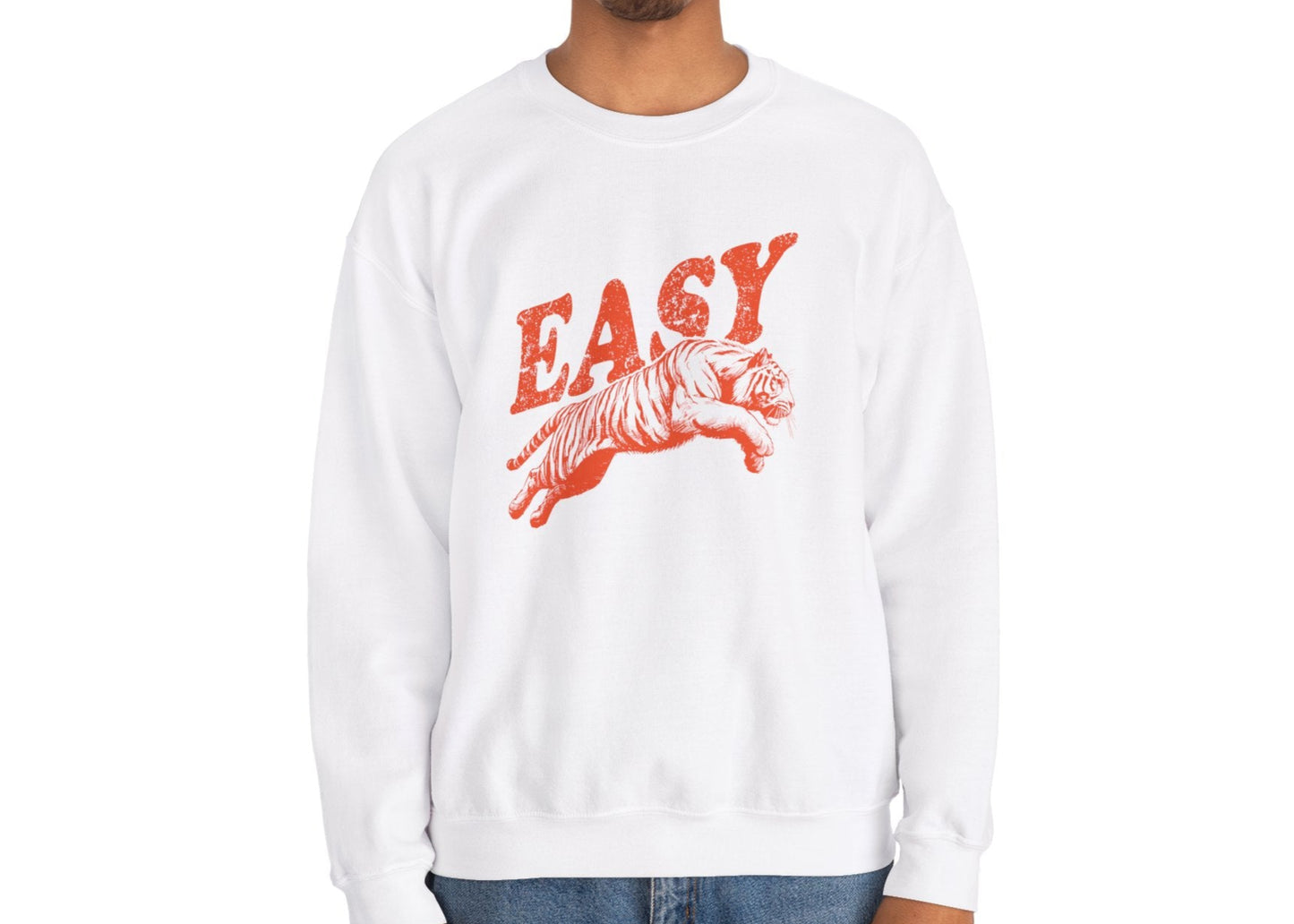Model wearing a white sweatshirt with "EASY" in orange letters and a leaping tiger graphic, standing with hands at sides. Part of the Vivid Divergence Sensory Friendly Unisex Sweater Jumper Range.