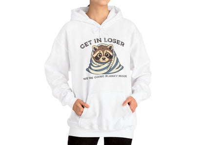 Model wearing a white hoodie with a raccoon wrapped in a blanket and the text "Get in Loser, We're Going Blanky Mode," standing with hands in pockets. Part of the Vivid Divergence Sensory Friendly Unisex Hoodie Range.
