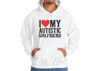 Model wearing a white hoodie with bold black text that reads "I ❤️ My Autistic Girlfriend," standing with hands in pockets. Part of the Vivid Divergence Sensory Friendly Unisex Hoodie Range.