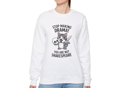 Model wearing a white sweatshirt with a cartoon cat holding a skull and the text "Stop Making Drama! You Are Not Shakespeare," standing with hands at sides. Part of the Vivid Divergence Sensory Friendly Unisex Sweater Jumper Range.