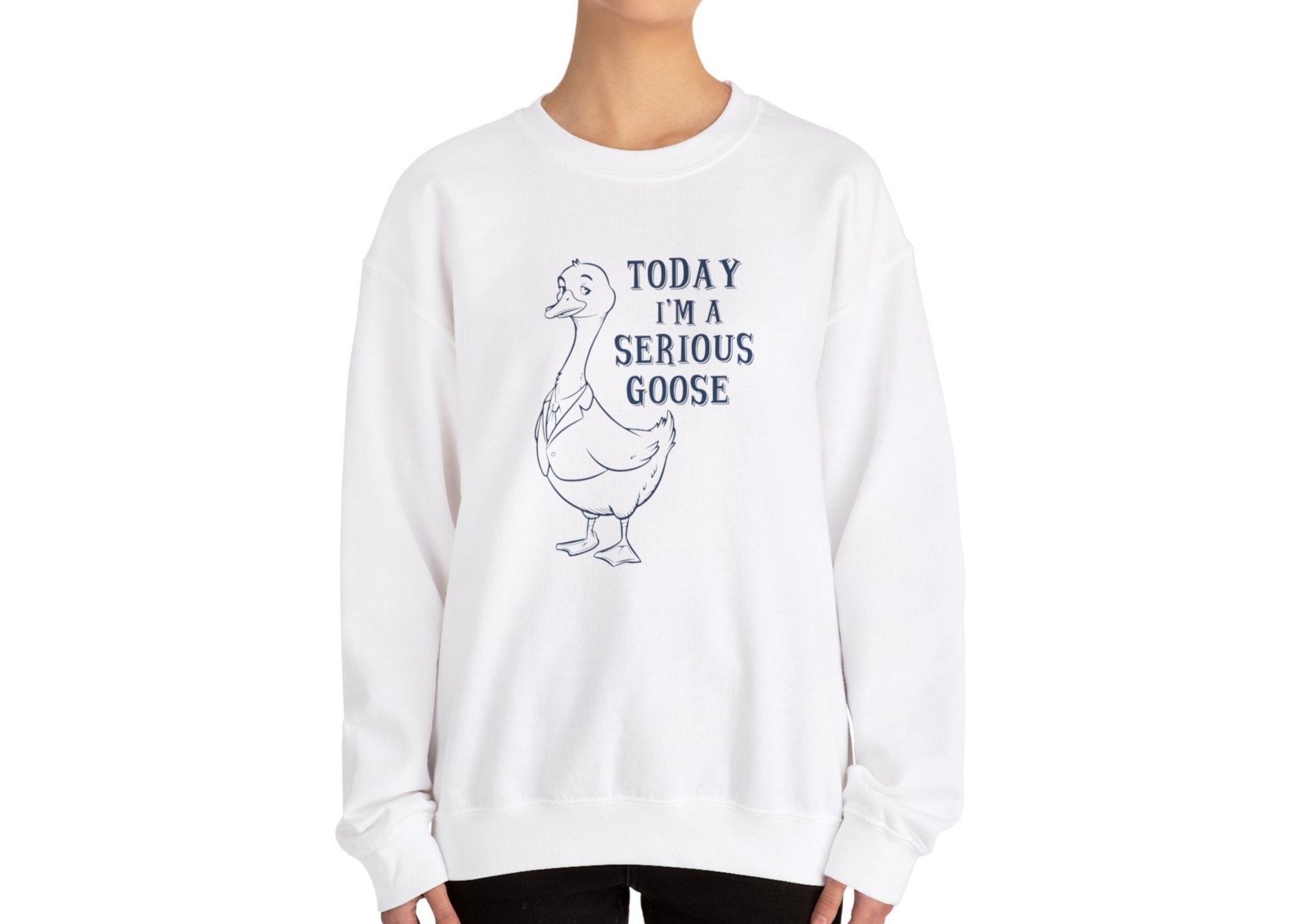 Model wearing a white sweatshirt with a cartoon goose and the text "Today I'm a Serious Goose," standing with hands at sides. Part of the Vivid Divergence Sensory Friendly Unisex Sweater Jumper Range.