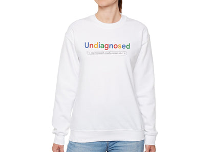 Model wearing a white sweatshirt with "Undiagnosed" in a Google-style font and a search bar graphic, standing with hands at sides. Part of the Vivid Divergence Sensory Friendly Unisex Sweater Jumper Range.