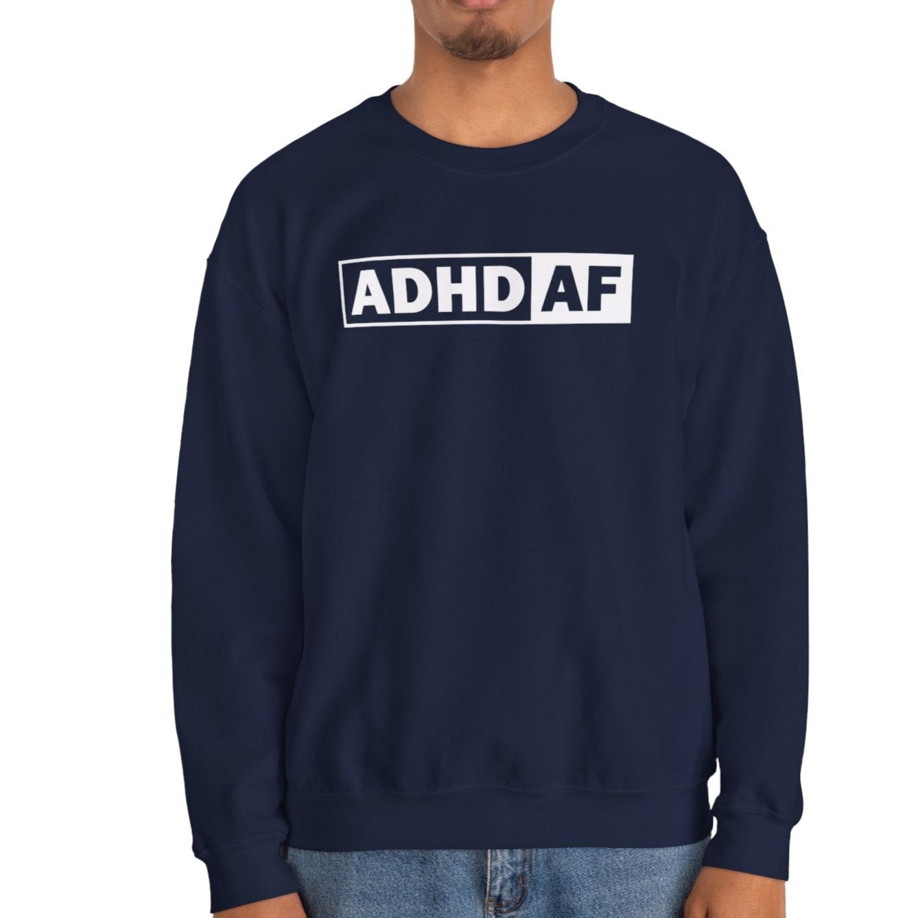 Model wearing a navy blue sweater jumper with "ADHD AF" text in bold white lettering. Part of the Vivid Divergence Sensory Friendly Unisex Sweater Jumper Range.