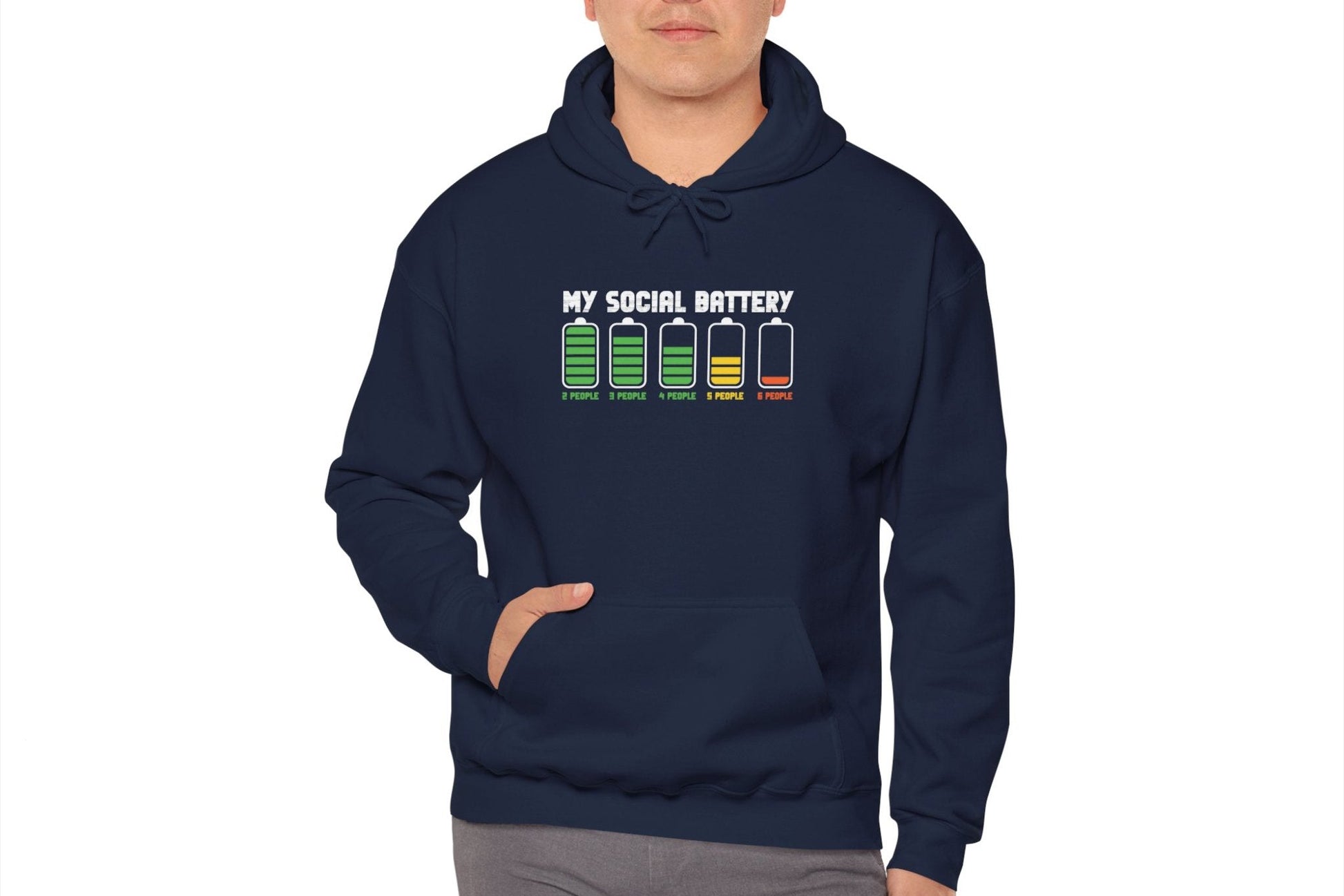 Model wearing a navy blue hoodie featuring the text "My Social Battery" with a series of battery icons decreasing from full to empty. Part of the Vivid Divergence Sensory Friendly Unisex Hoodie Range.