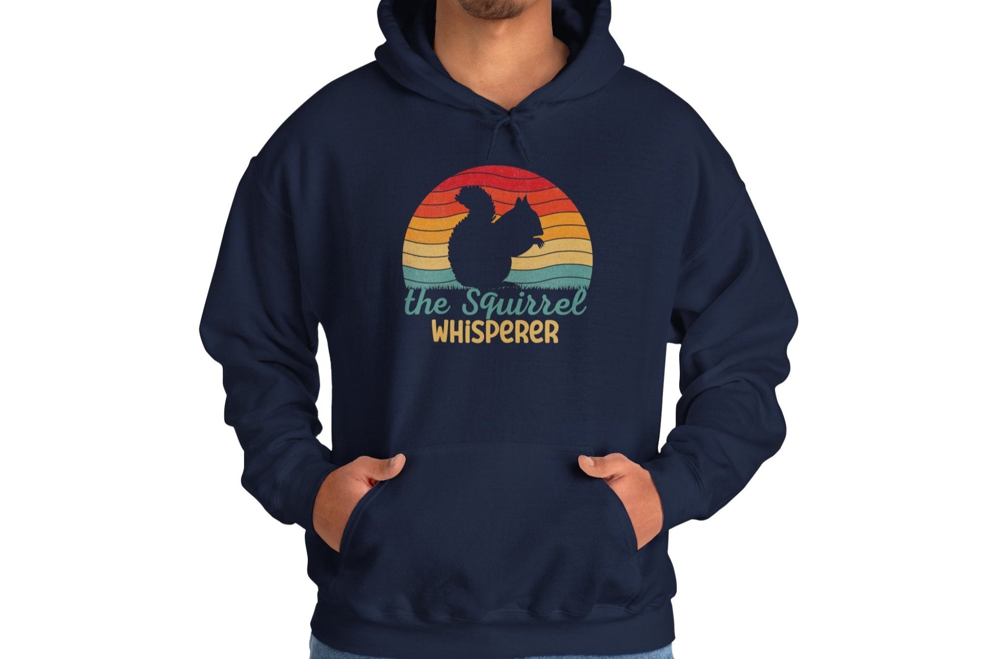 Model wearing a navy blue hoodie featuring the text "Squirrel Whisperer" with an ADHD mascot design of a squirrel and a retro sunset background. Part of the Vivid Divergence Sensory Friendly Unisex Hoodie Range.
