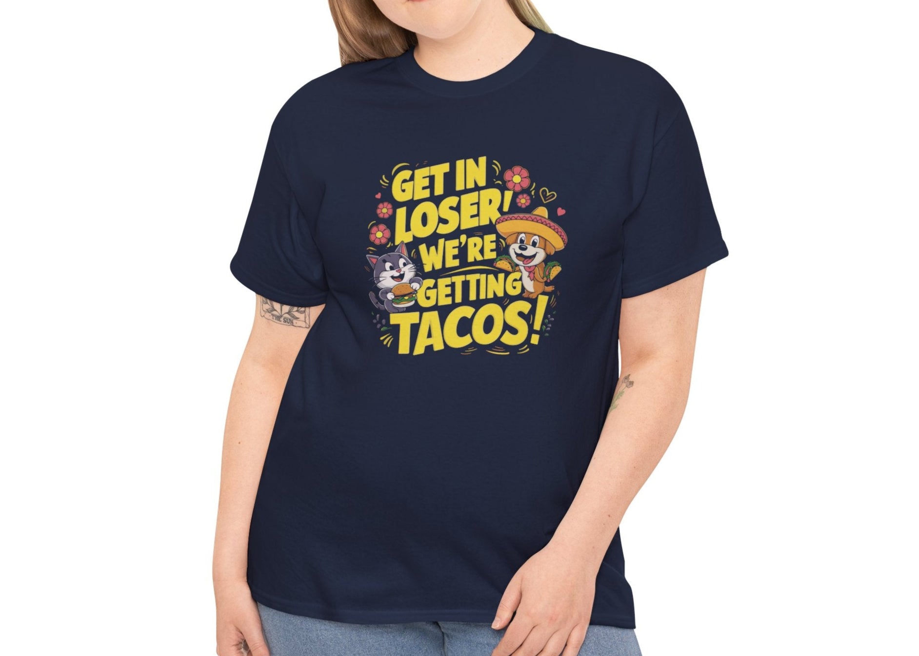 Modeled front view of a navy blue T-shirt with colorful text and illustrations of cute animals in a car that reads "Get In Loser, We're Getting Tacos!" Part of the Vivid Divergence Sensory Friendly Unisex Tees Range.