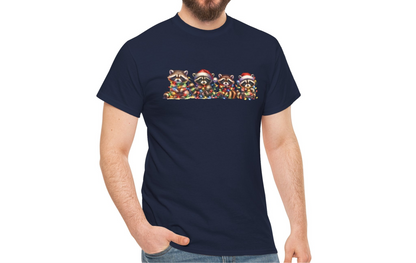 Model wearing a navy blue T-shirt featuring a festive illustration of raccoons in Christmas attire causing holiday chaos, styled casually. Part of the Vivid Divergence Sensory Friendly Unisex Tees Range.