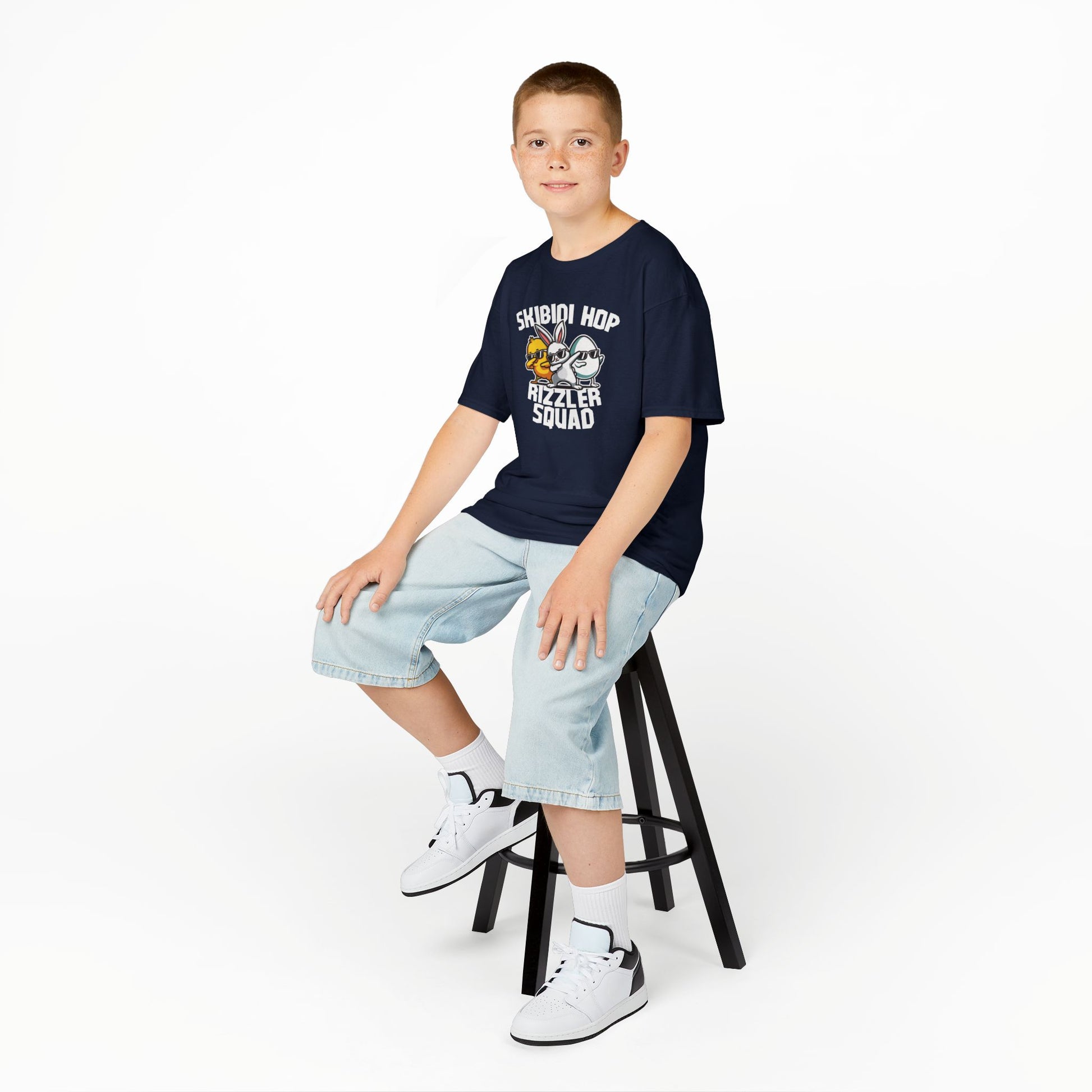 Child wearing a navy Easter T-shirt featuring a Skibidi-themed "Rizzler Squad" meme design, a fun and bold choice. Hop into the season in style and shop Easter shirts online today!