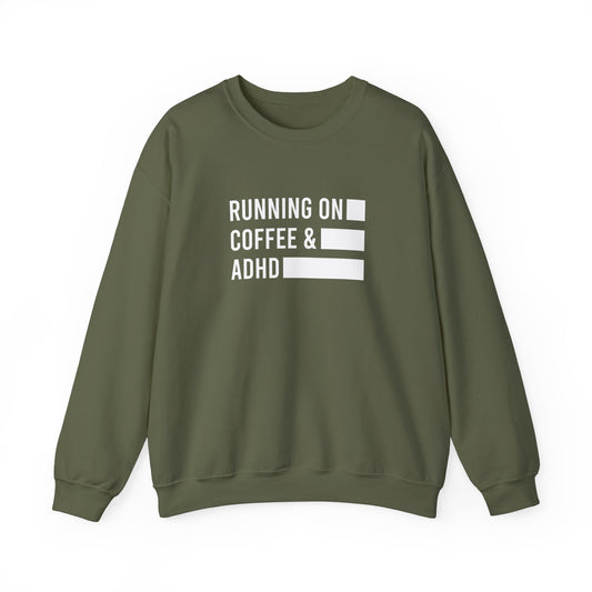 Front view of an olive green sweater jumper with the text "Running on Coffee & ADHD" in bold white lettering and a battery graphic. Part of the Vivid Divergence Sensory Friendly Unisex Sweater Jumper Range.