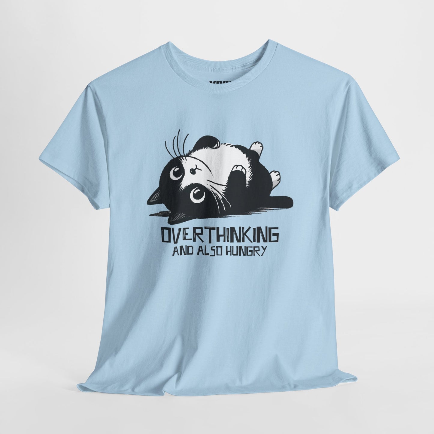 Hanging view of light blue T-shirt featuring black line art of a wide-eyed cat surrounded by scribbles, with the phrase "Overthinking and also hungry." A whole vibe. Part of the Vivid Divergence Memewear Collection!