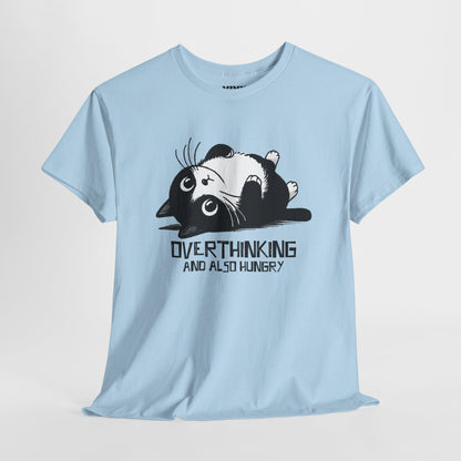 Hanging view of light blue T-shirt featuring black line art of a wide-eyed cat surrounded by scribbles, with the phrase "Overthinking and also hungry." A whole vibe. Part of the Vivid Divergence Memewear Collection!