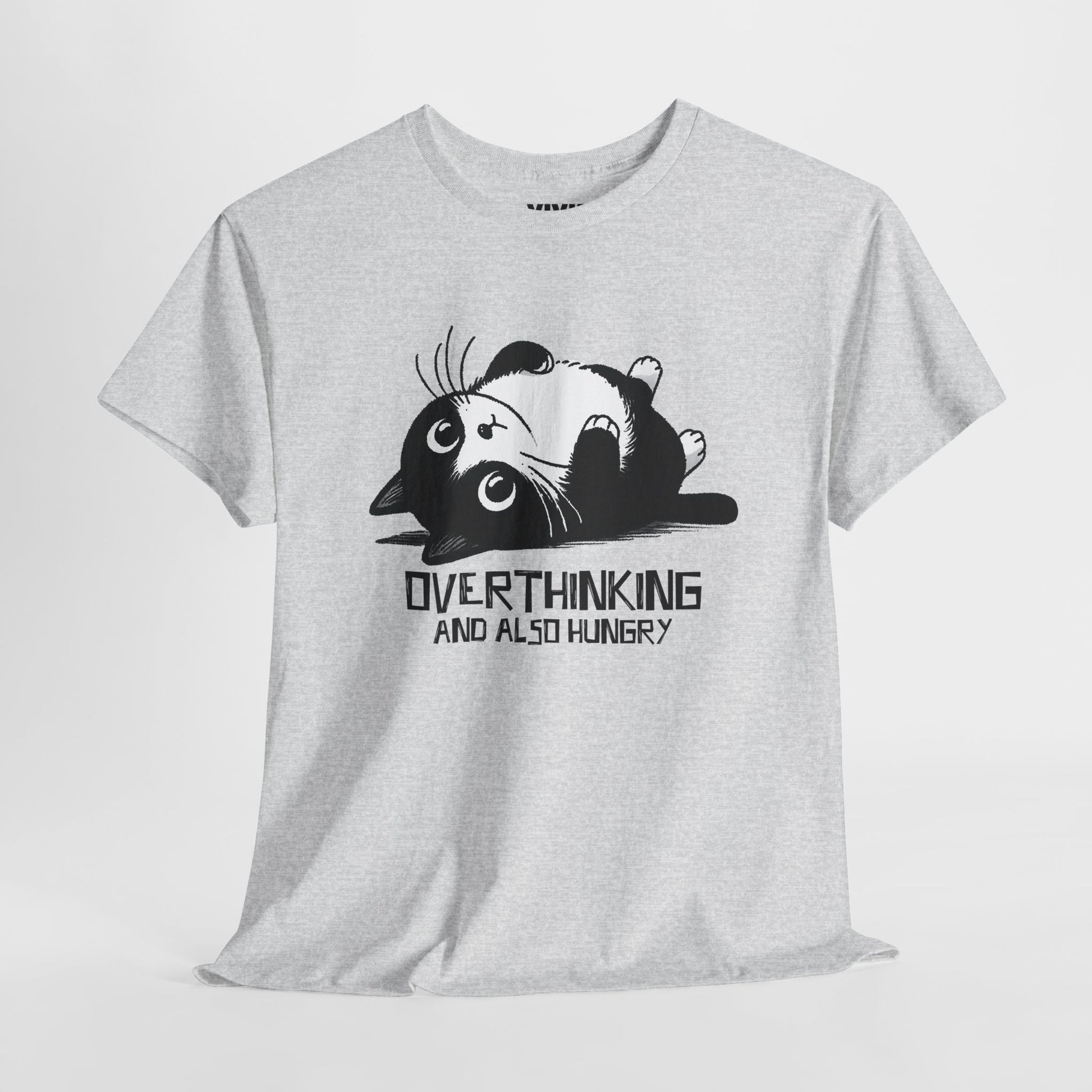 Hanging view of light grey T-shirt featuring black line art of a wide-eyed cat surrounded by scribbles, with the phrase "Overthinking and also hungry." A whole vibe. Part of the Vivid Divergence Memewear Collection!