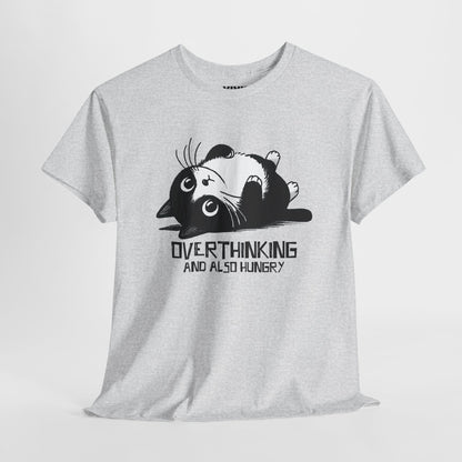 Hanging view of light grey T-shirt featuring black line art of a wide-eyed cat surrounded by scribbles, with the phrase "Overthinking and also hungry." A whole vibe. Part of the Vivid Divergence Memewear Collection!