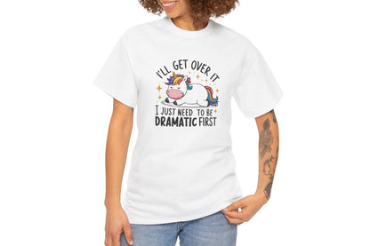 A person wearing a white T-shirt with a unicorn and cow graphic and the text "I'll Get Over It, I Just Need To Be Dramatic First." Part of the Vivid Divergence Sensory Friendly Unisex Tees Range.