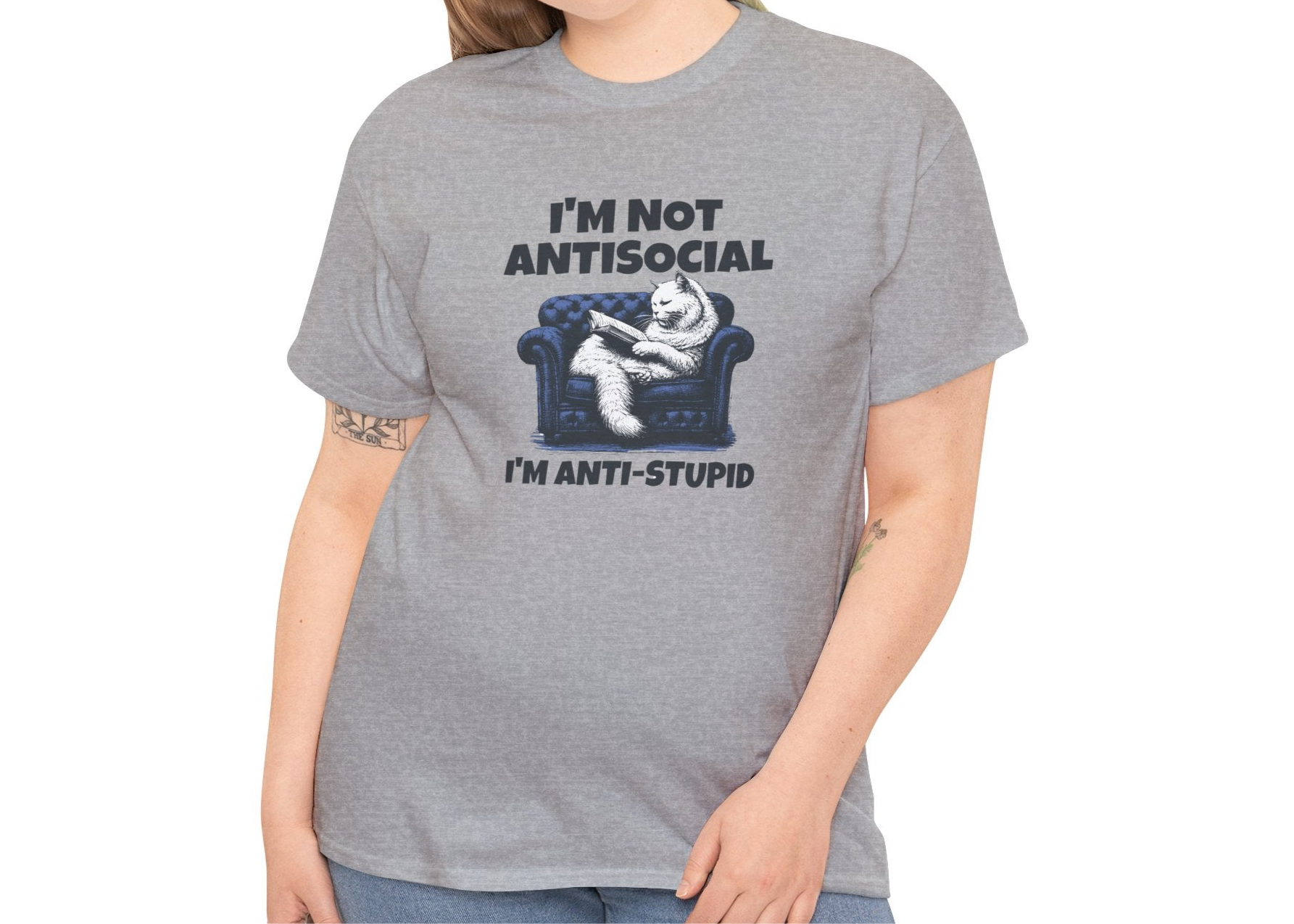 A person wearing a gray T-shirt with a graphic of a cat on a couch and the text "I'm Not Anti-Social, I'm Anti-Stupid." Part of the Vivid Divergence Sensory Friendly Unisex Tees Range.