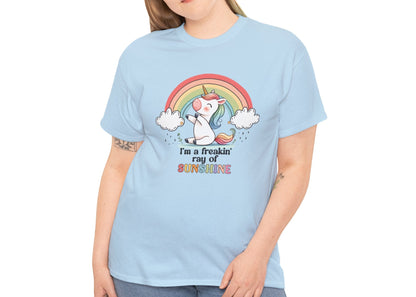 A person wearing a light blue T-shirt with a rainbow and unicorn graphic and the text "I'm A Freakin Ray Of Sunshine." Part of the Vivid Divergence Sensory Friendly Unisex Tees Range.