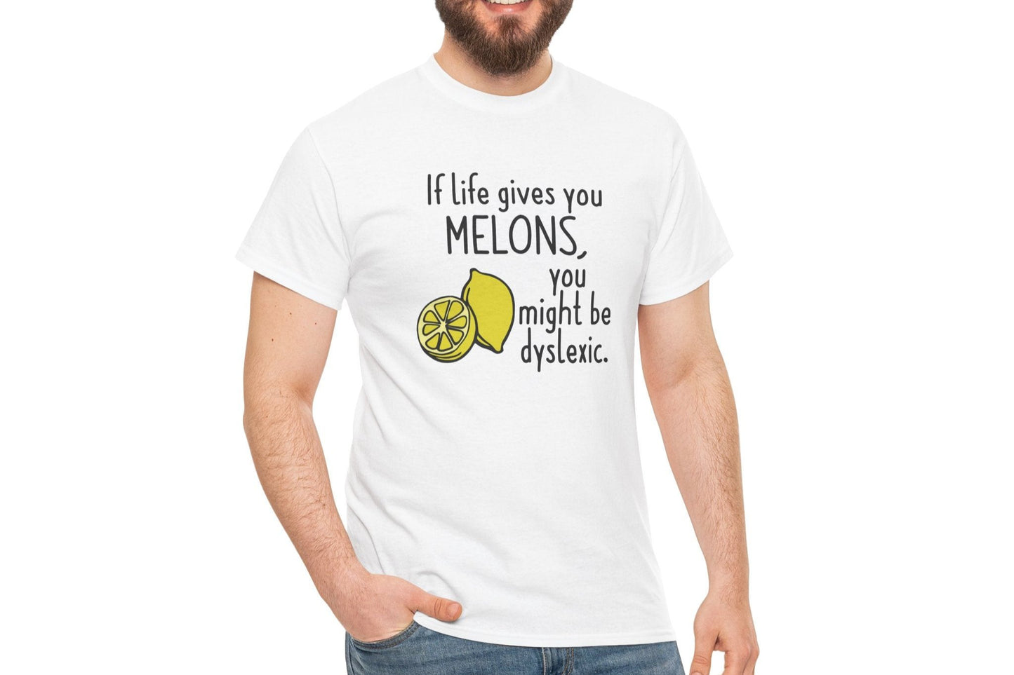 A person wearing a white T-shirt with a lemon and melon graphic and the text "If life gives you melons, you might be dyslexic." Part of the Vivid Divergence Sensory Friendly Unisex Tees Range.