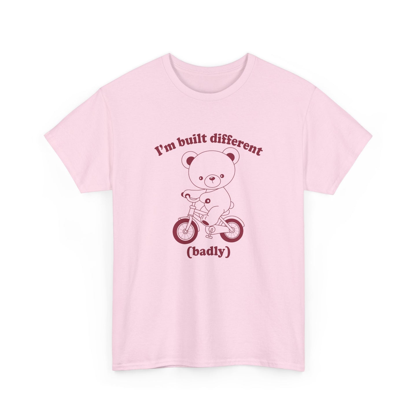 Front view of a pink T-shirt featuring the "Built Different (Badly)" bear design. Part of the Vivid Divergence Sensory Friendly Unisex Tees Range.