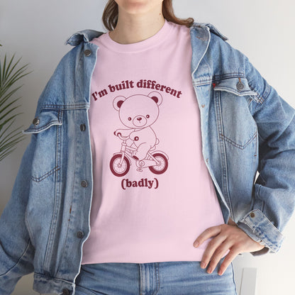 Model wearing a pink T-shirt with the "Built Different (Badly)" bear design. Part of the Vivid Divergence Sensory Friendly Unisex Tees Range.