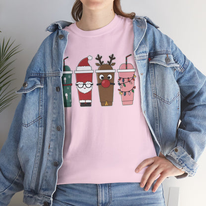 Model wearing a pink T-shirt featuring a festive illustration of four iced coffee cups decorated with Christmas designs, styled in a cozy indoor setting. Part of the Vivid Divergence Sensory Friendly Unisex Tees Range.