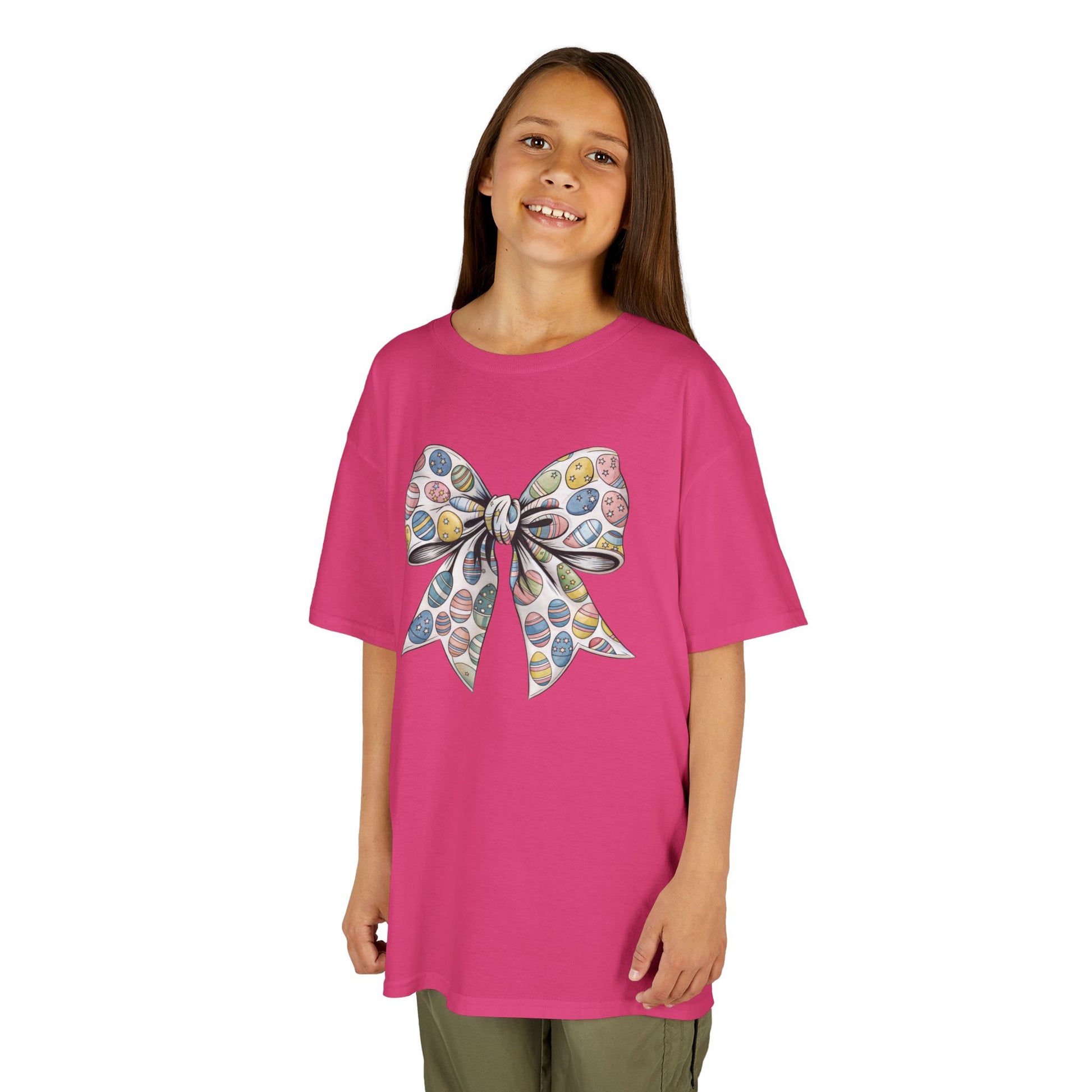 Child wearing a pink Easter T-shirt with a floral bow in a coquette aesthetic, perfect for a stylish holiday look. Hop into the season in style and shop Easter shirts online today!