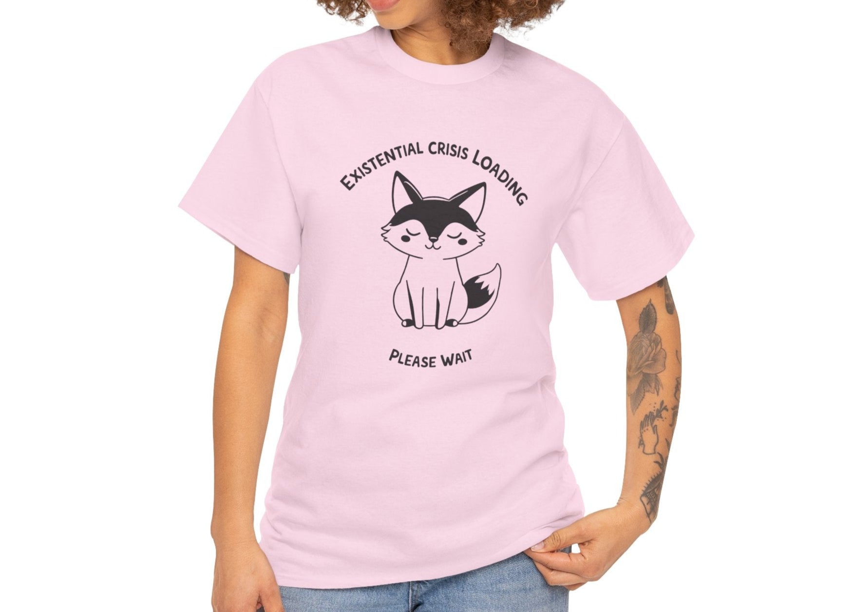 Woman with curly hair wearing a light pink T-shirt with a black and white fox graphic and "Existential Crisis Loading, Please Wait" text. Part of the Vivid Divergence Sensory Friendly Unisex Tees Range.