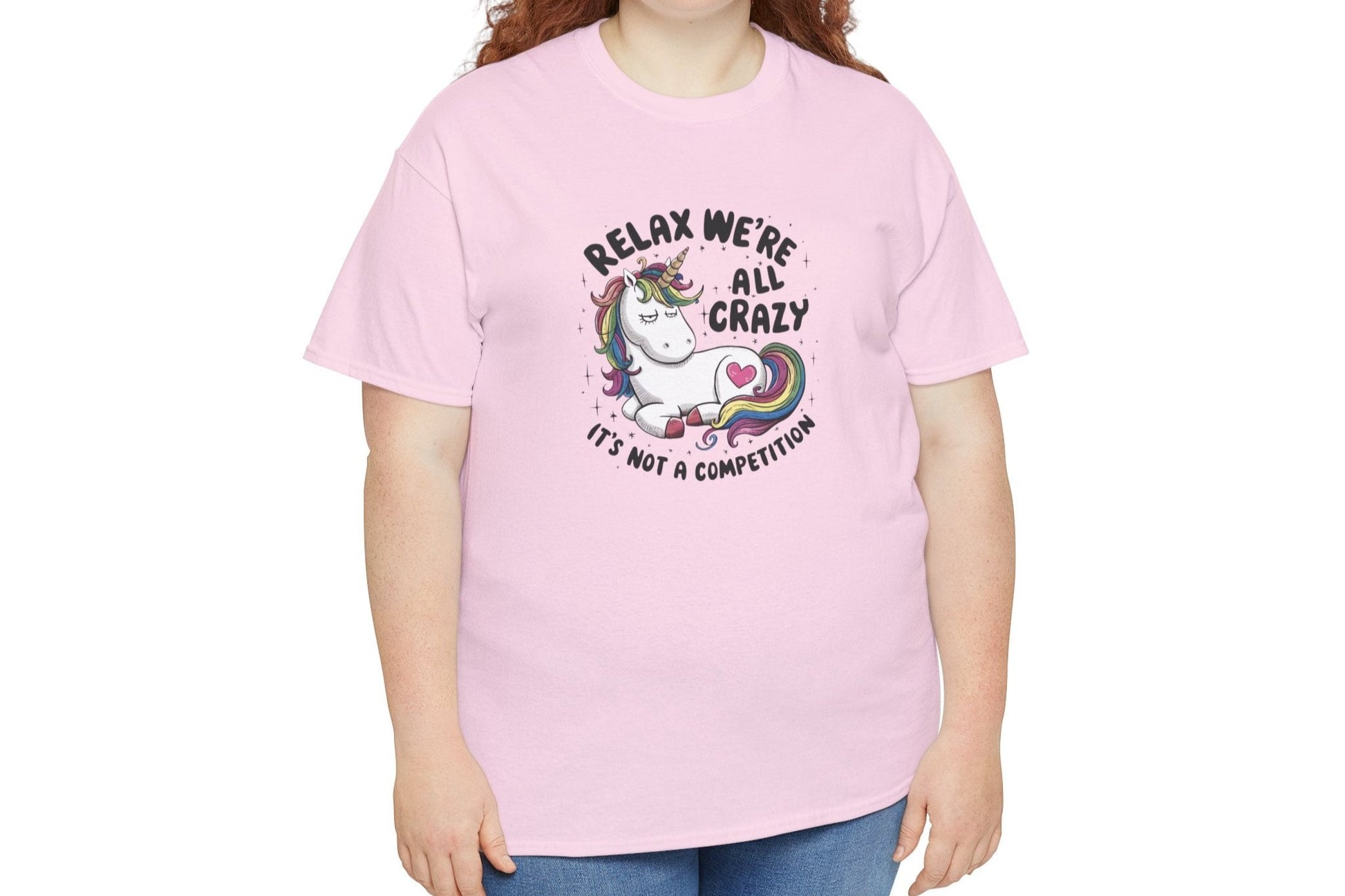Model wearing a pink T-shirt with "Relax, We're All Crazy" and a whimsical cat graphic in black text. Part of the Vivid Divergence Sensory Friendly Unisex Tees Range.