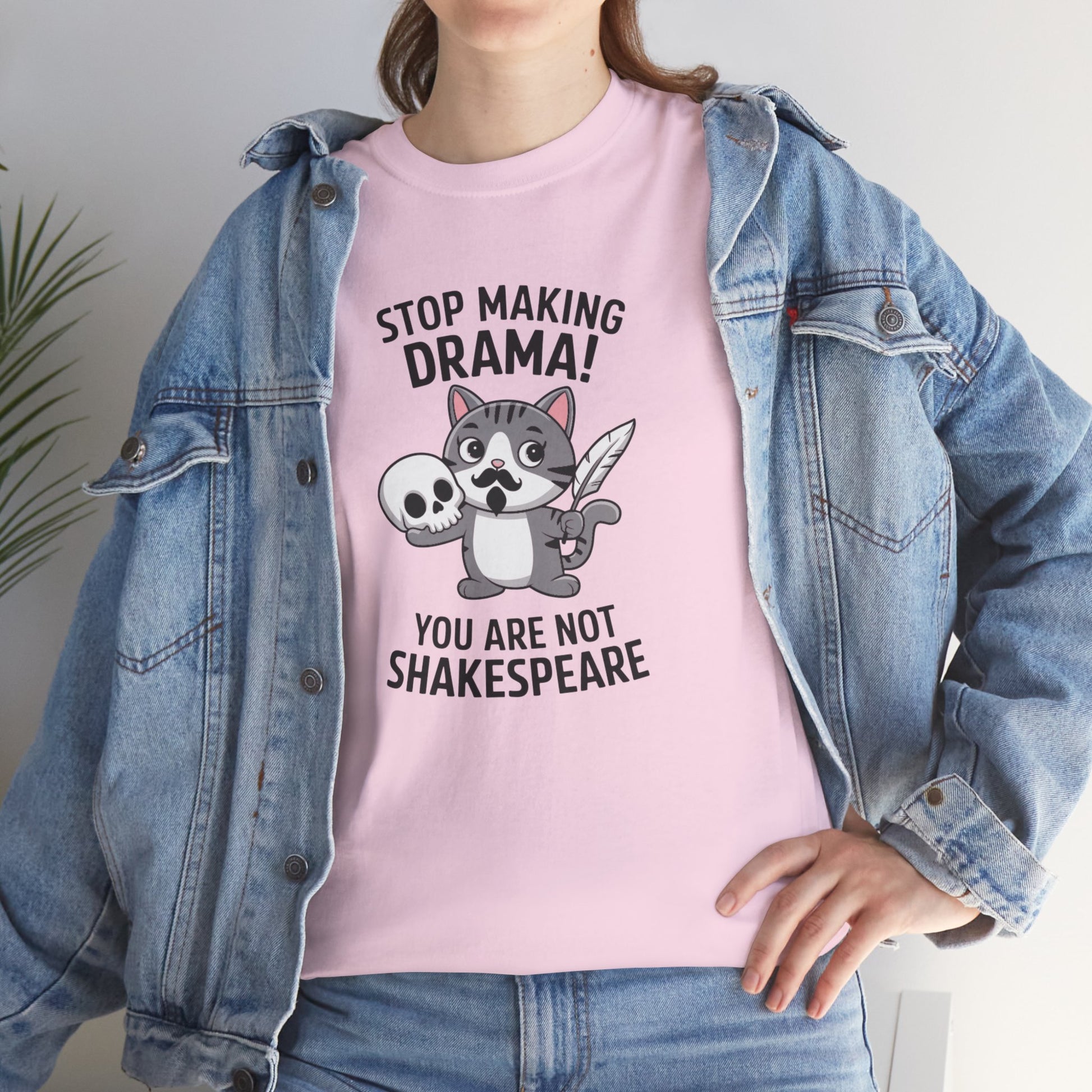 Modeled front view of a pink T-shirt featuring a cute cat holding a skull and text that reads "Stop Making Drama! You Are Not Shakespeare." Part of the Vivid Divergence Sensory Friendly Unisex Tees Range.