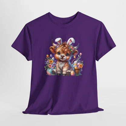 Purple T-shirt hanging, showcasing a fluffy Highland cow with bunny ears and spring-themed accents, a playful Easter outfit. Hop into the season in style and shop Easter shirts online today!