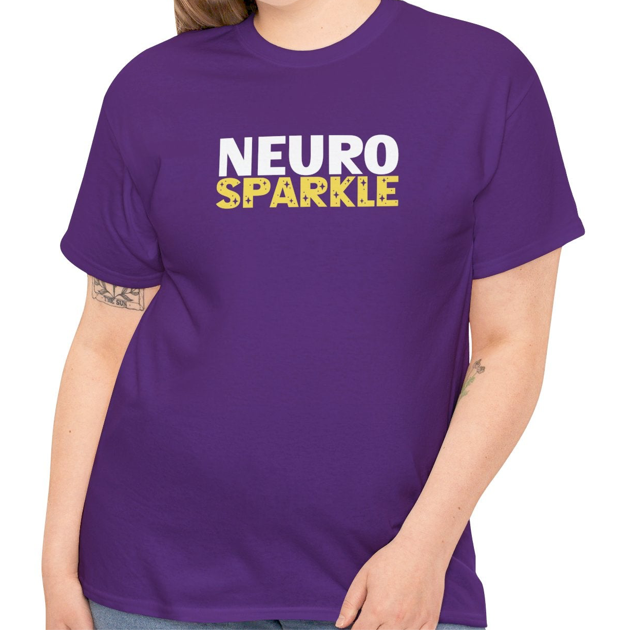 Model wearing a purple T-shirt with "Neurosparkle" in bold white and yellow text. Part of the Vivid Divergence Sensory Friendly Unisex Tees Range.