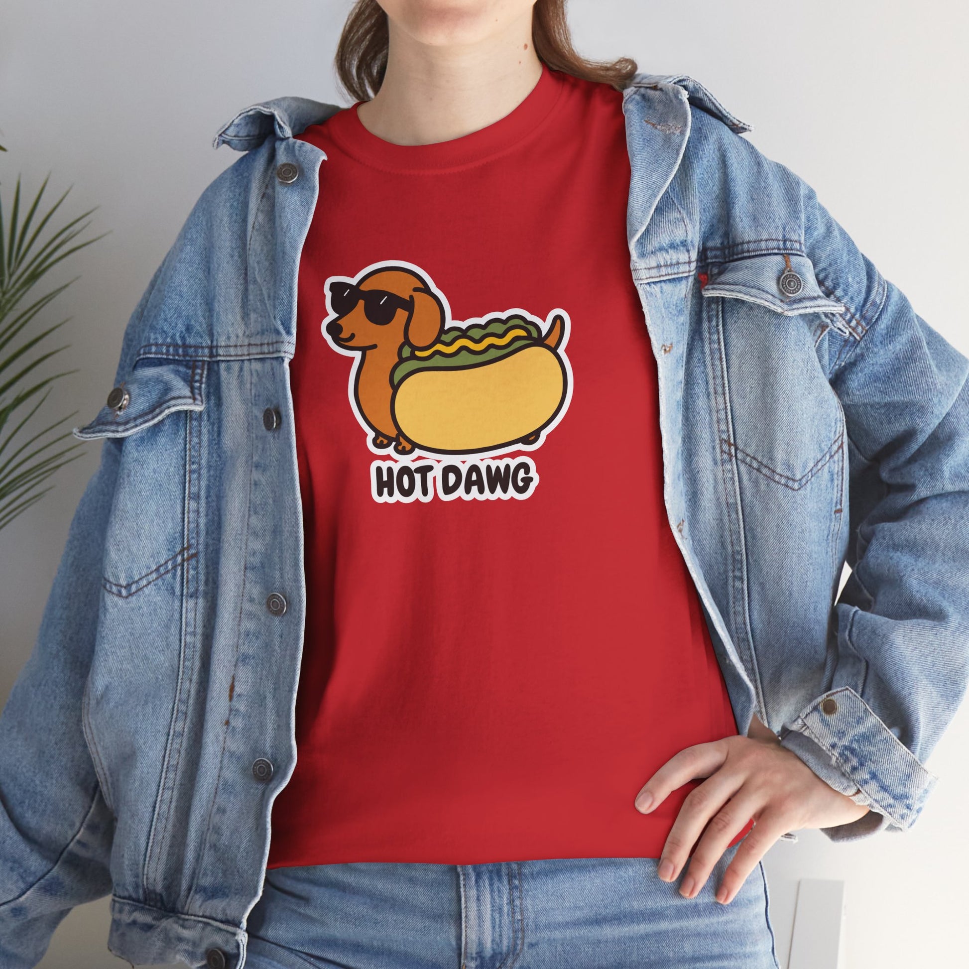 Model wearing a red T-shirt featuring a "Hot Dawg" design with a cartoon dachshund inside a hot dog bun wearing sunglasses. Part of the Vivid Divergence Sensory Friendly Unisex Tees Range.