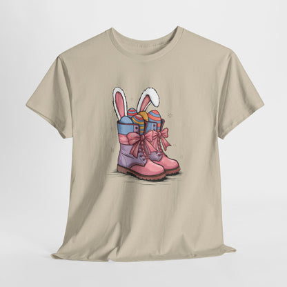 Sand T-shirt hanging, showcasing cowgirl boots with bunny ears and Easter eggs, a rustic and charming holiday outfit. Hop into the season in style and shop Easter shirts online today!