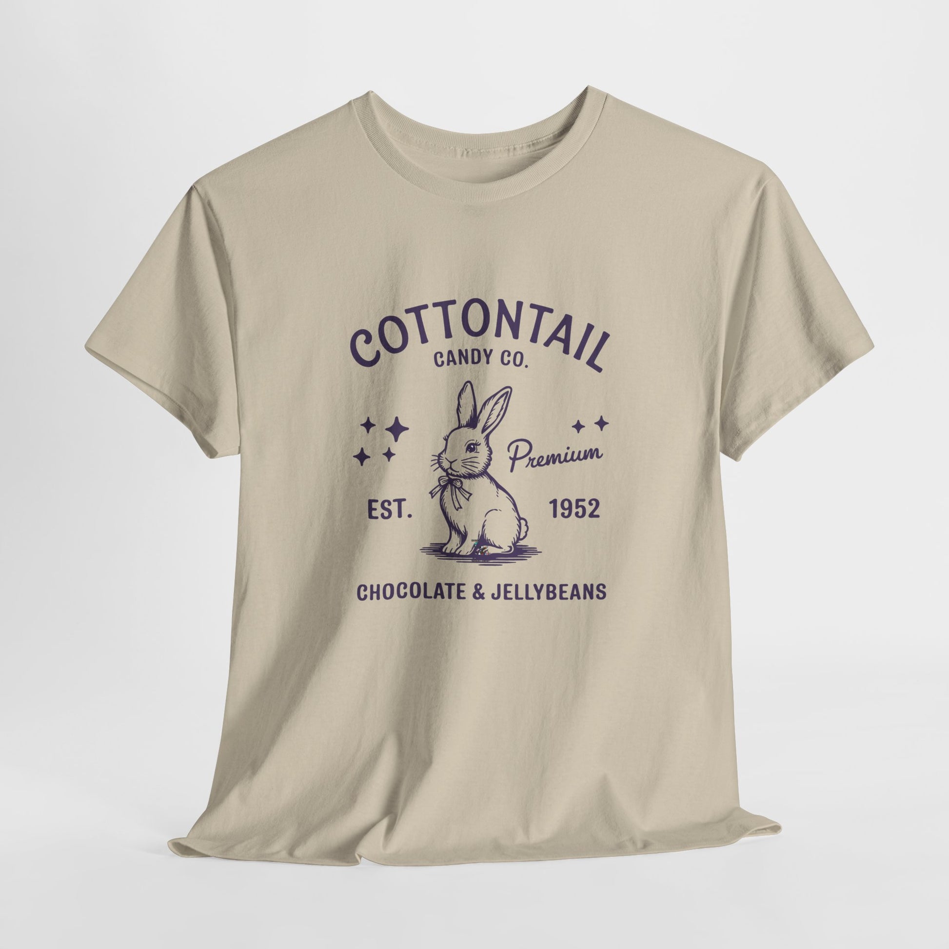 Sand T-shirt hanging, decorated with a classic "Cottontail Candy Co." logo featuring a nostalgic bunny, ideal for a timeless Easter look. Hop into the season in style and shop Easter shirts online today!