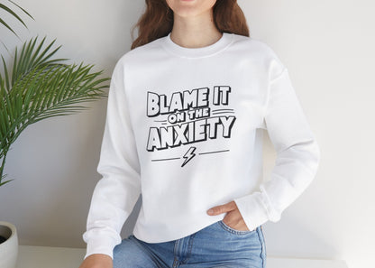 Model seated, wearing a white sweatshirt with bold text that reads "Blame It on the Anxiety." Part of the Vivid Divergence Sensory Friendly Unisex Sweater Jumper Range.