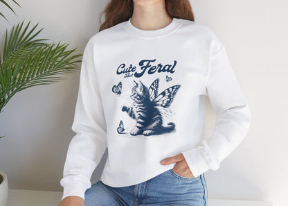 Model seated, wearing a white sweatshirt with a graphic of a cat surrounded by butterflies and the text "Cat Feral." Part of the Vivid Divergence Sensory Friendly Unisex Sweater Jumper Range.