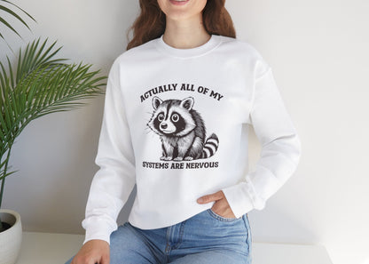 Model seated, wearing a white sweatshirt with a raccoon graphic and the text "Actually All of My Systems Are Nervous." Part of the Vivid Divergence Sensory Friendly Unisex Sweater Jumper Range.