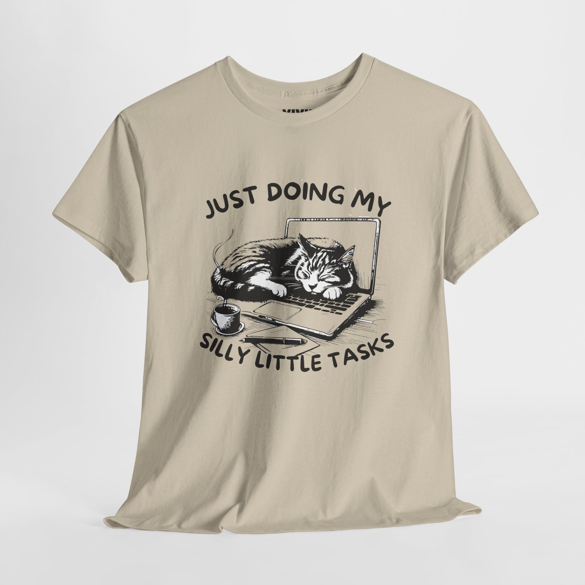 Beige meme T-shirt with laptop cat graphic hanging on a hanger. Doing the least in the cutest way. Part of the Vivid Divergence Memewear Collection!
