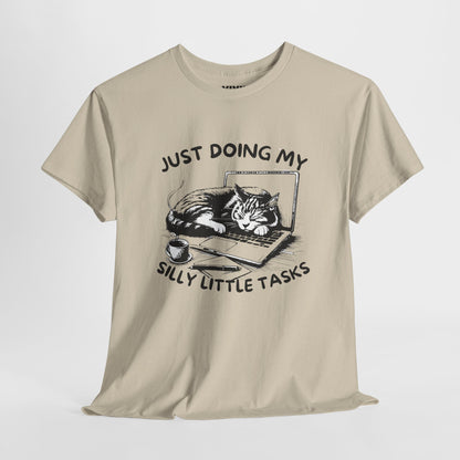 Beige meme T-shirt with laptop cat graphic hanging on a hanger. Doing the least in the cutest way. Part of the Vivid Divergence Memewear Collection!
