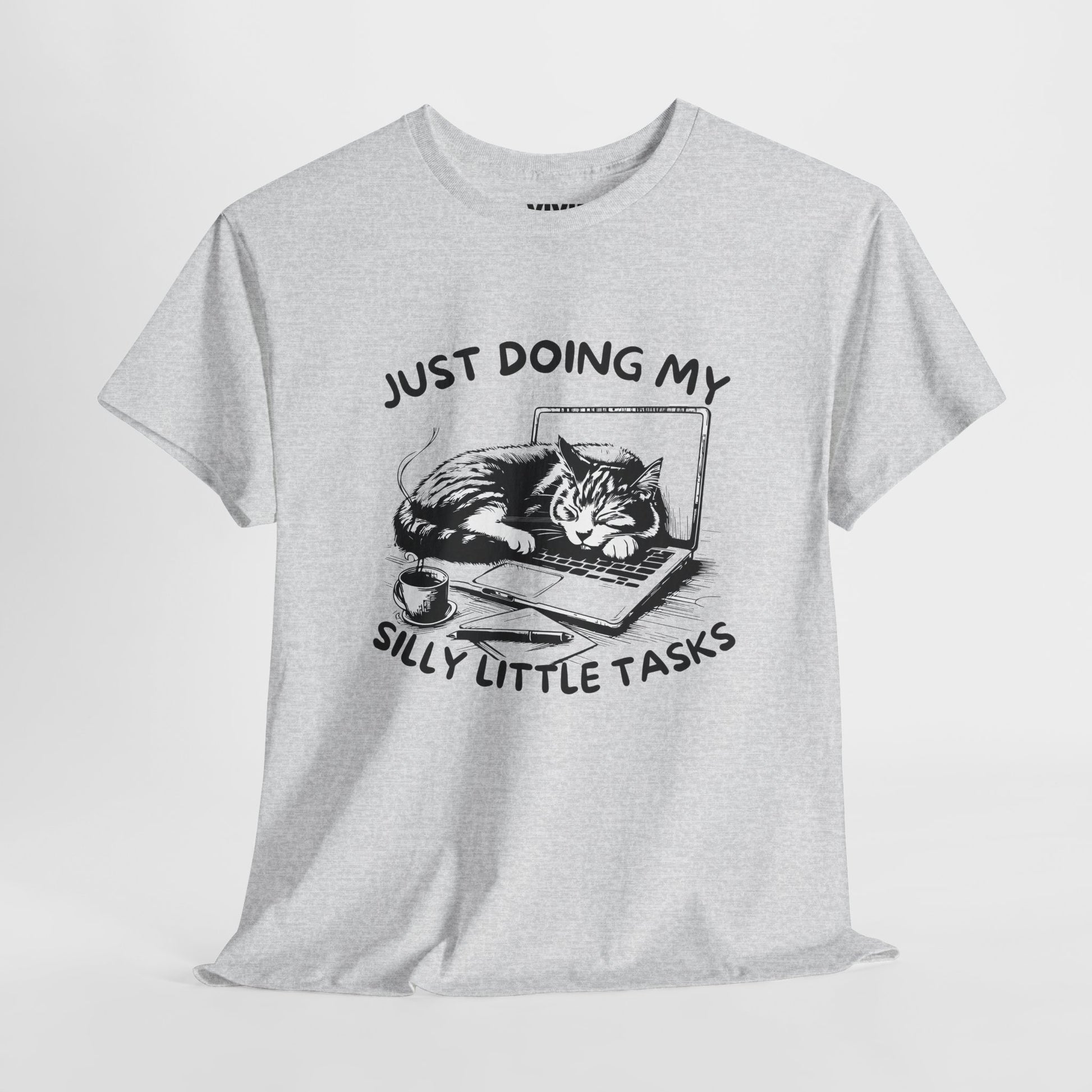 Ash gray “Just Doing My Silly Little Tasks” T-shirt hanging against neutral background. The cat is working hard (but actually sleeping). Part of the Vivid Divergence Memewear Collection!

