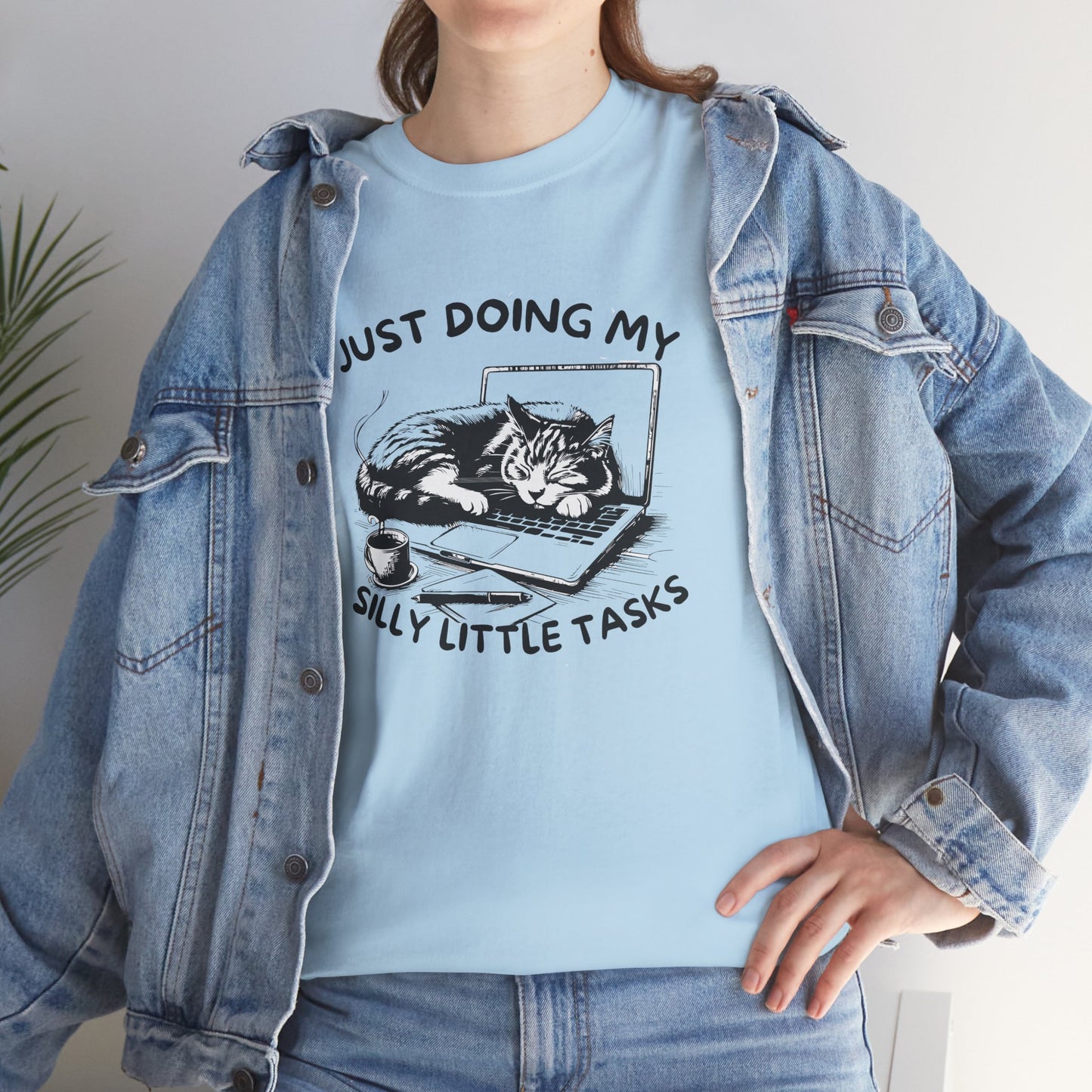 Woman in light blue cat-on-laptop T-shirt smiling with arms at sides. Currently avoiding every real responsibility. Part of the Vivid Divergence Memewear Collection!
