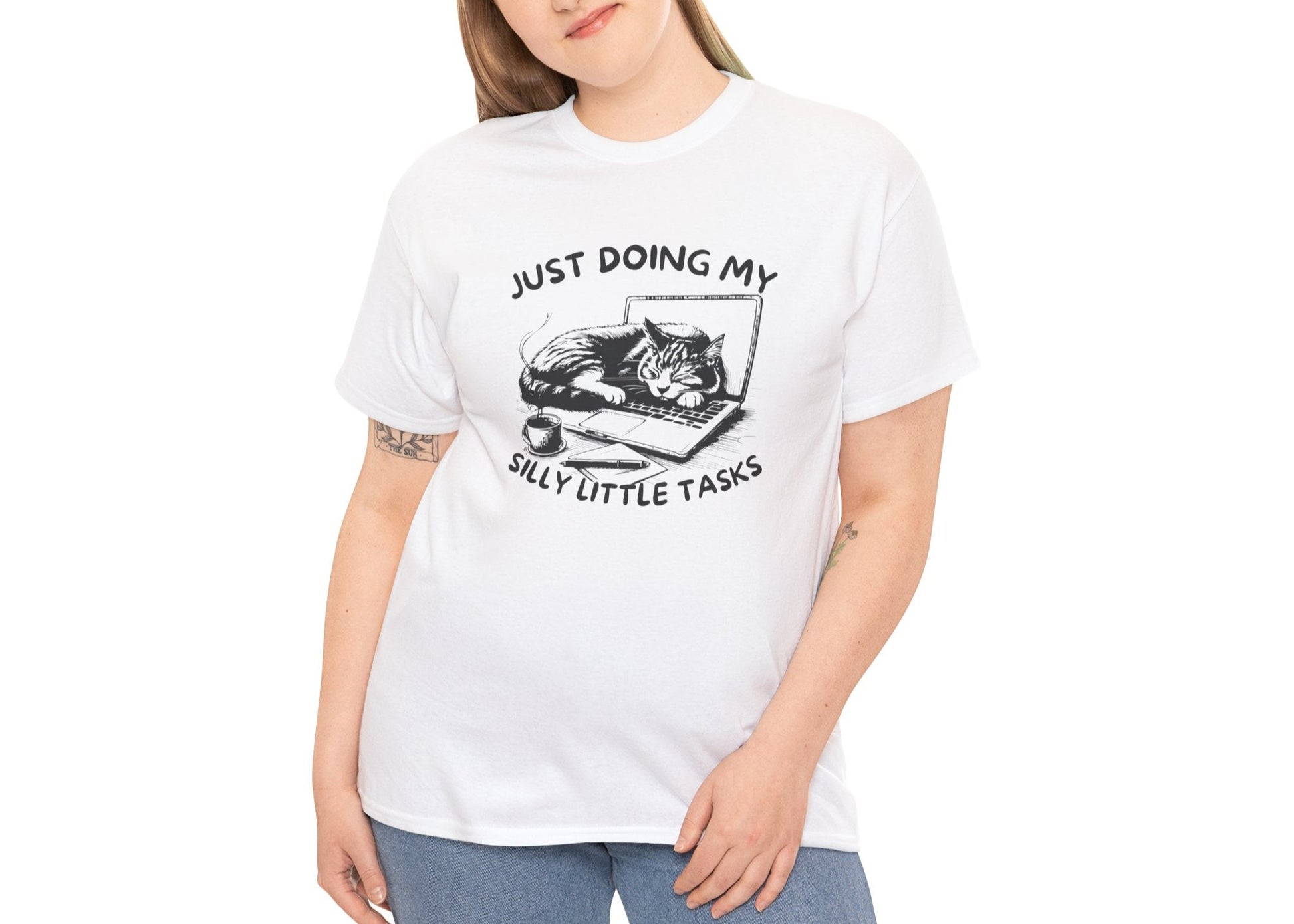 Woman modeling white silly little tasks cat T-shirt, smiling softly. She's channeling “productive” energy while accomplishing nothing. Part of the Vivid Divergence Memewear Collection!
