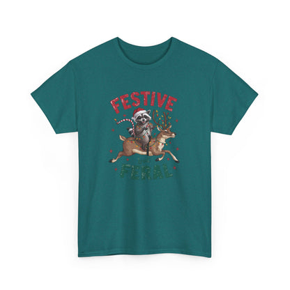 Front view of a teal T-shirt featuring a festive illustration of a raccoon (trash panda) holding Christmas lights and the text "Festive but Feral." Part of the Vivid Divergence Sensory Friendly Unisex Tees Range.