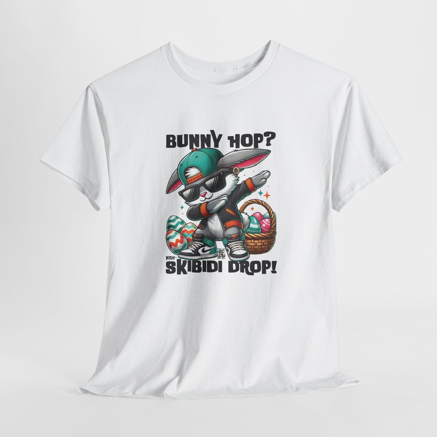 Hanging view of a viral meme-inspired T-shirt in white. Features a graphic design of a dabbing Easter bunny with text that says, "Bunny Hop? Nah, Skibidi Drop!" A fun, bold shirt radiating skibidi sigma rizz energy for Easter. Part of the Vivid Divergence Sensory Friendly Unisex Tees Range.