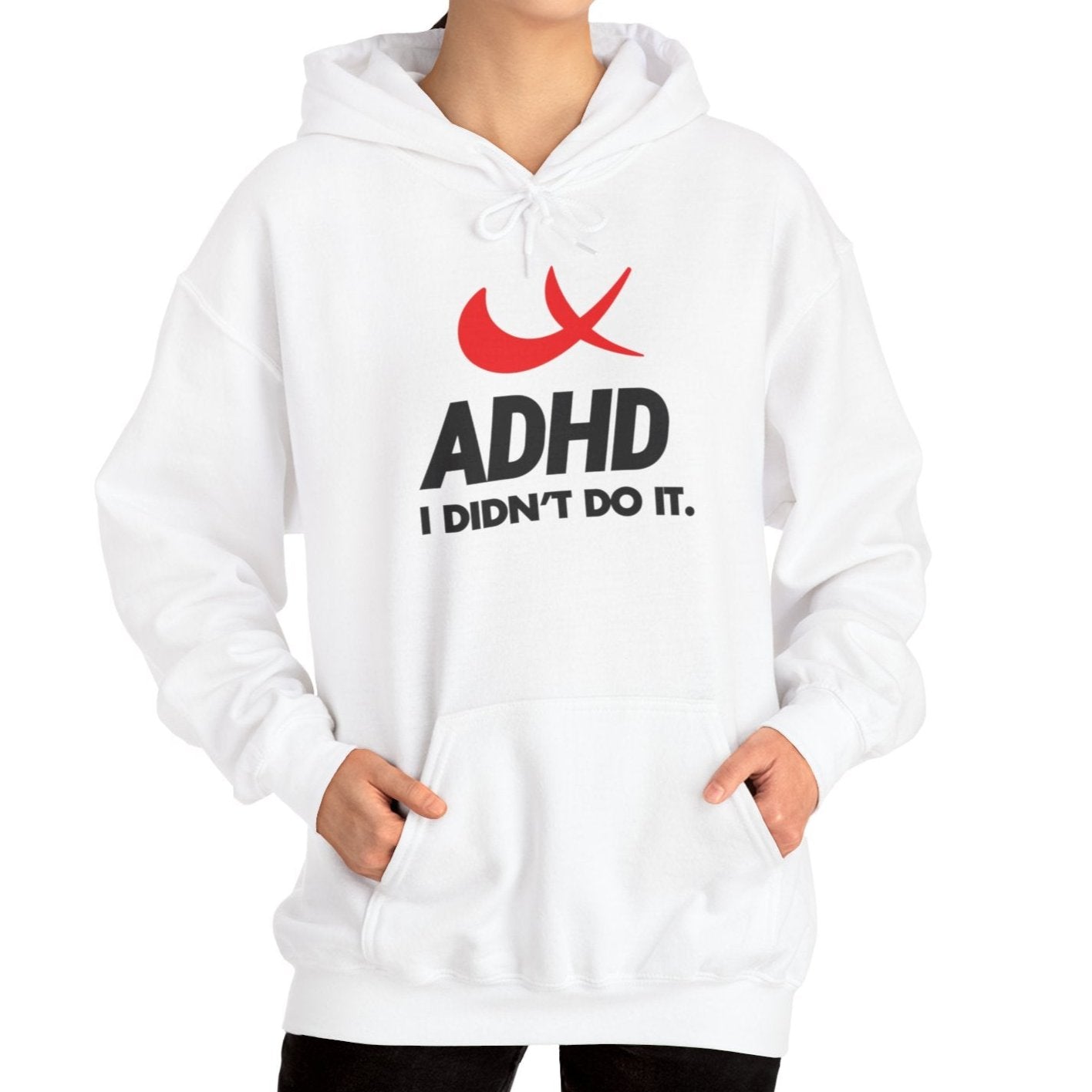 Model wearing a white hoodie with a Nike parody design featuring a red swoosh and the text "ADHD, I Didn’t Do It." Part of the Vivid Divergence Sensory Friendly Unisex Hoodie Range.
