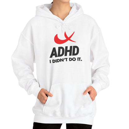 Model wearing a white hoodie with a Nike parody design featuring a red swoosh and the text "ADHD, I Didn’t Do It." Part of the Vivid Divergence Sensory Friendly Unisex Hoodie Range.
