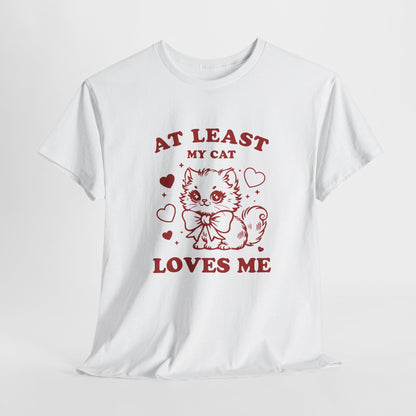 Hanging view of a white T-shirt with red text and cat illustration that reads "At Least My Cat Loves Me." Exclusive release for Valentine’s Day. Part of the Vivid Divergence Sensory Friendly Unisex Tees Range.
