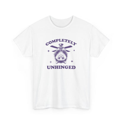 Front view of a white T-shirt featuring "Completely Unhinged" text with a cat hanging upside down from a ceiling fan in purple design. Part of the Vivid Divergence Sensory Friendly Unisex Tees Range.